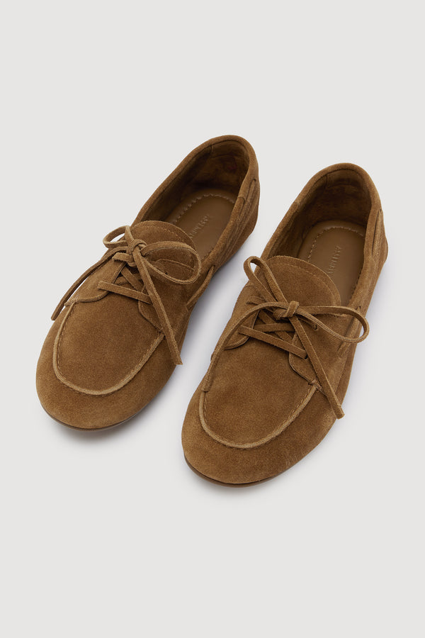 Pair of brown suede loafers on a light gray background